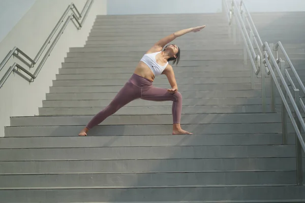 根据在公共场所做瑜伽的趋势 亚洲的中国女士在楼梯上做瑜伽 — 图库照片