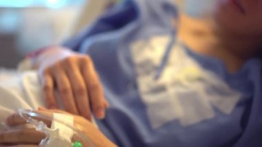 Asyalı Çinli Anne Hastanın hastane yatağında dinlenirken çekilmiş titrek ve el kamerası görüntüleri.