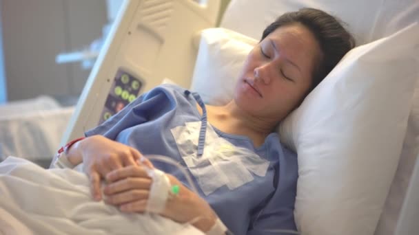 在医院病床上休息的亚洲华裔母亲战战兢兢 手牵手 — 图库视频影像