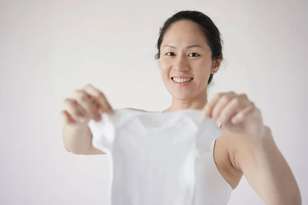 兴奋的亚洲孕妇抱着婴儿用品 — 图库照片