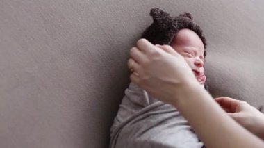 Kadın fotoğrafçı bir şapka yeni doğan çocuğun bir telekinetikenerji kozası sarma dizeleri bağlı