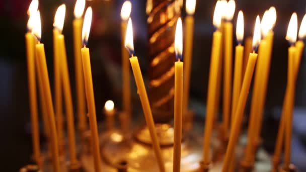 Зажженные свечи в храме в сумерках — стоковое видео