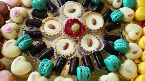 Cukorka, csokoládé, mandula, szív alakú süteményeket, tésztákat, süteményeket be van állítva a büféasztal. — Stock videók