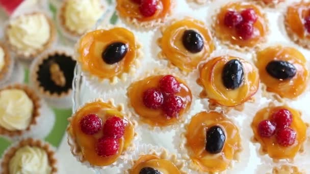 Торты с фруктами и ягодами выкладываются в витрине — стоковое видео