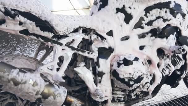 A man washes a motorcycle with foam on a car washer — Stock Video