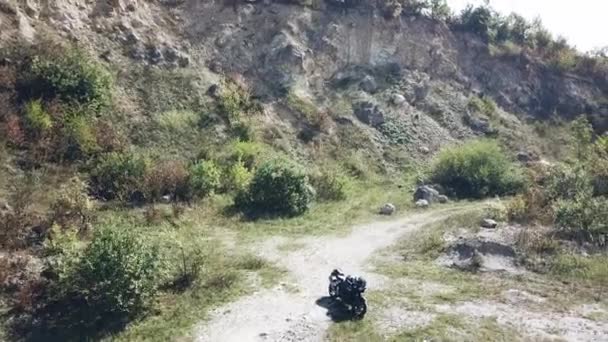 La motocicleta se encuentra en medio de un camino de tierra — Vídeos de Stock