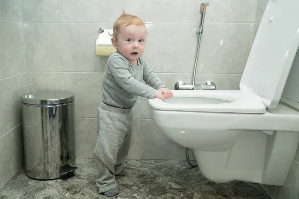 Un petit garçon curieux regarde dans les toilettes — Photo