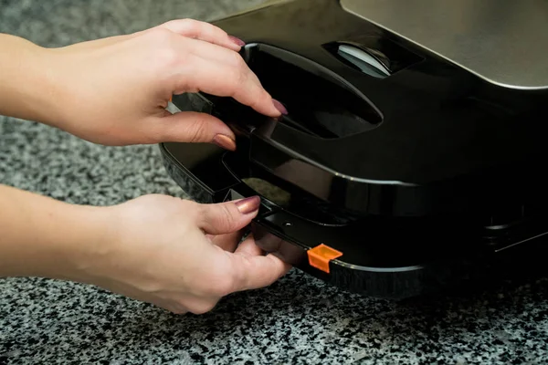 Opened Electronic Waffle maker with a women hand. Sample model for Kitchen appliance