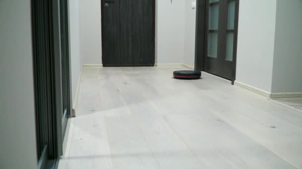 Ρομποτική ηλεκτρική σκούπα στο φυλλόμορφο ξύλινο πάτωμα. Έξυπνη τεχνολογία καθαρισμού. Ηλεκτρική σκούπα καθαρισμού στο διαμέρισμα — Αρχείο Βίντεο