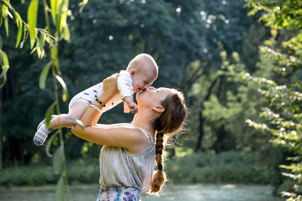 Parkta duran bebek oğluyla mutlu anne. Anne ile küçük oğlu Parkı'nda oynarken