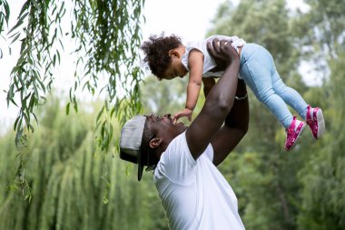 Kızı tutan bir baba. Mutlu baba ile kızı parkta oynarken