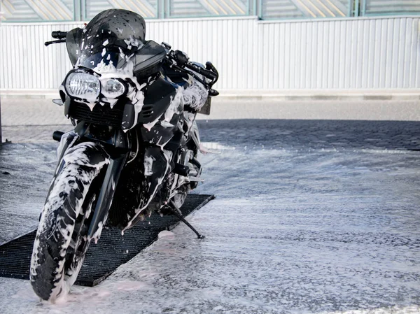 Lavage moto noire. Nettoyage moto Gros plan. Mousse de nettoyage sur le vélo — Photo