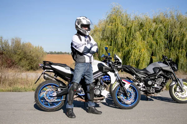 Pengendara sepeda motor dengan helm mengendarai sepeda motor. Perjalanan ke sepeda motor. Motorcyclist berdiri di jalan — Stok Foto