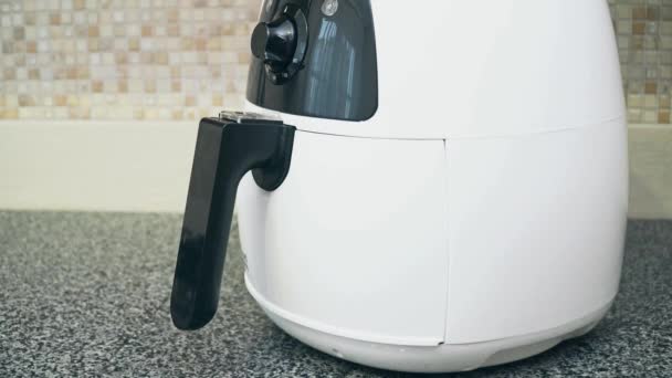 Front wiew of a deep fryer for home use. A man opens the fryer — Stock Video