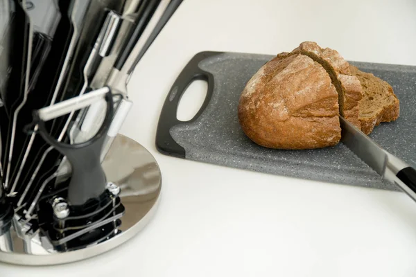 Pan y cuchillo en rodajas. Set de seis cuchillos de cocina en una cocina moderna — Foto de Stock