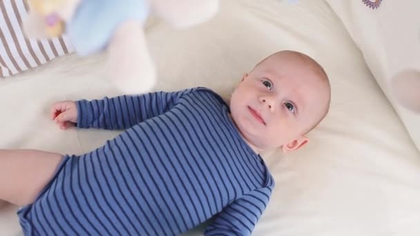 Lindo niño feliz de 6 meses mintiendo y jugando — Vídeos de Stock