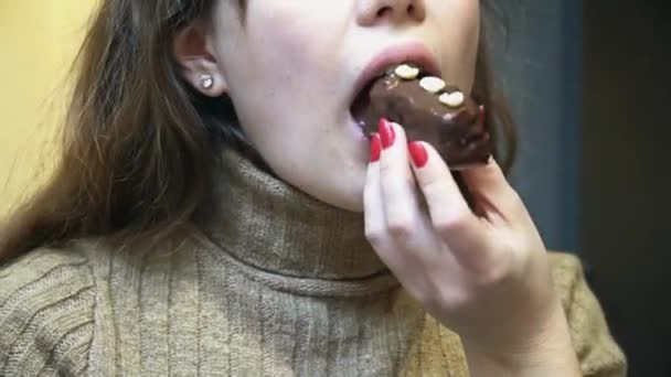 Μια γυναίκα τρώει ένα κέικ σοκολάτας με ξηρούς καρπούς, κοντινό πλάνο — Αρχείο Βίντεο