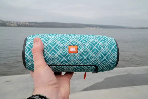 Ternopil, Ukrayna - 14 Nisan 2019: Adam göl kenarında Jbl bluetooth hoparlör tutar