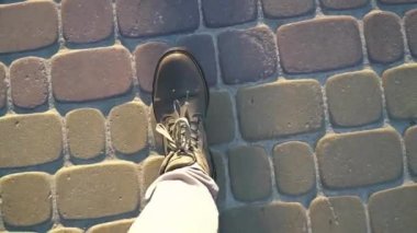 Bir adam gün batımında kaldırıma çıkıyor.