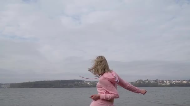 Jovem dançarina caucasiana feliz na rua urbana rosa dançando freestyle na cidade junto ao lago — Vídeo de Stock
