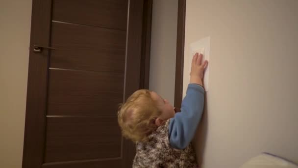 Маленький мальчик выключает свет в комнате — стоковое видео