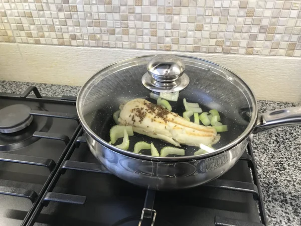 Grande casserole avec poisson et céleri dans la cuisine moderne sur une cuisinière à gaz — Photo