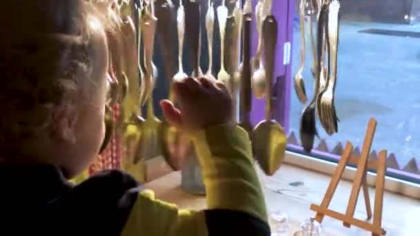 A little boy is played with decorative tableware in a cafe — Stock Video