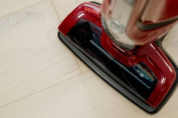 Red vacuum cleaner on the wooden floor. Cleaning home — Stock Photo, Image