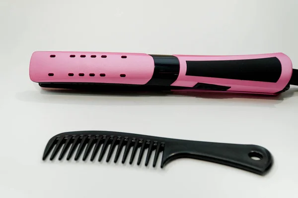 Rose hair straightener with black comb on white. Hair care — Stock Photo, Image