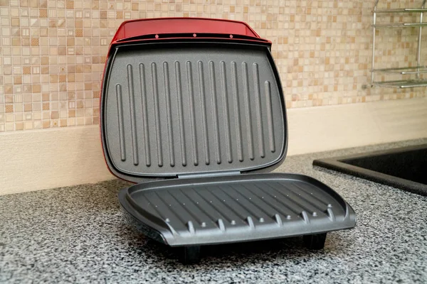 Rode elektrische grill op grijze keuken tafel — Stockfoto