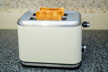 Kahvaltı için kızarmış ekmek ile tost makinesi içinde. Gri tablo