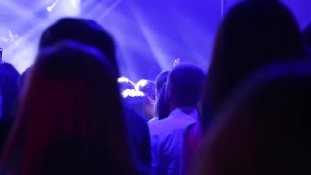 Pessoas de silhueta em uma multidão com as mãos para cima dançando. Multidão de concertos no festival de música ao vivo — Vídeo de Stock