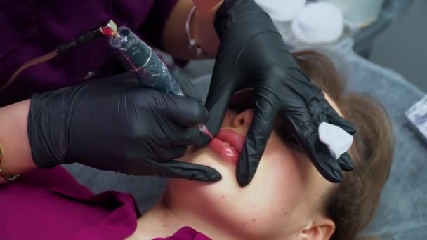 Permanent make up. Kosmetolog tillämpa permanent makeup på läppar — Stockvideo