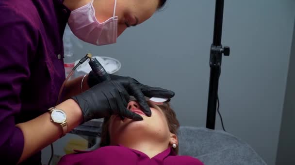 Spa sana: cosmetologo che applica trucco permanente sulle labbra — Video Stock