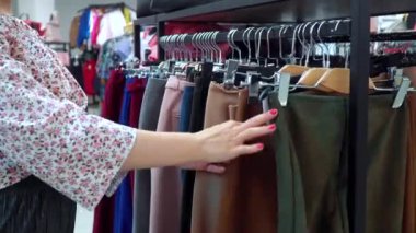 Alışveriş kızı. Güzel kız butik bir pantolon seçti