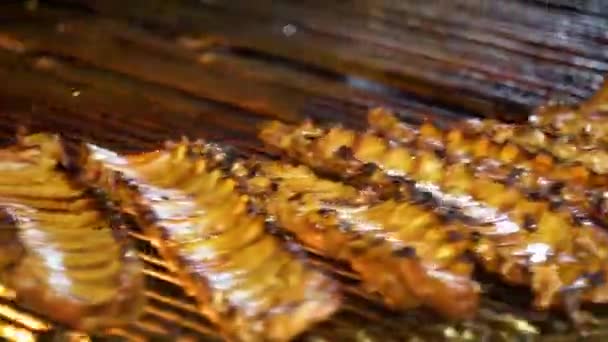 Cozinhar salsichas de churrasco. Costelas de porco suculentas com crosta grelhada na grelha — Vídeo de Stock