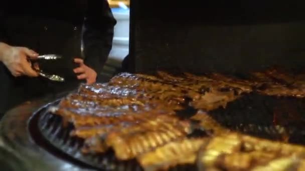 Cook turns meat on the grill. Cooking barbecue sausages. Pork ribbons — Stock Video