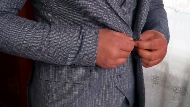 Homme mains boutonnage veste fermer. Homme élégant dans un costume boutons de fixation sur sa veste — Video