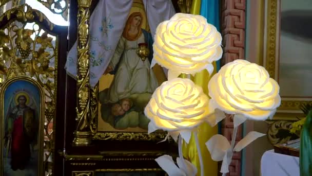 Kunstmatige lichte bloemen in de orthodoxe kerk — Stockvideo