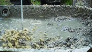 Builder elektrikli karıştırıcı ile beton sıva karıştırır. Kum ve çimento karıştırma. Yavaş çekim