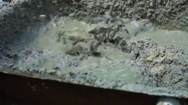 Builder elektrikli karıştırıcı ile beton sıva karıştırır. El kitabında beton hazırlanması