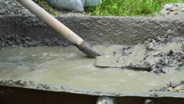 Builder mixing concrete with water and sand for building. Slow motion — Stock Video