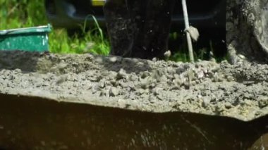 Builder elektrikli karıştırıcı ile beton sıva karıştırır. El kitabında beton hazırlanması