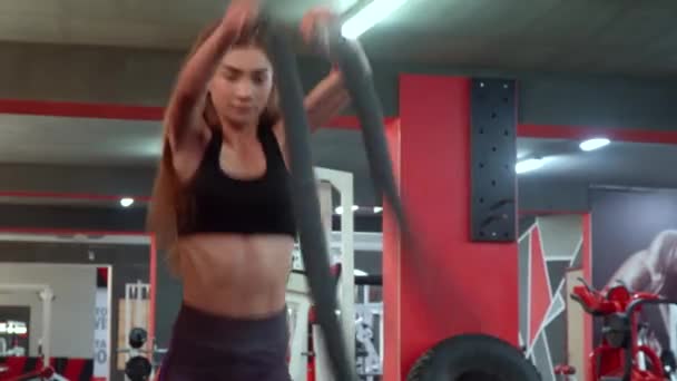 Spor kulübünde güzel kız simülatörleri üzerinde egzersizleri farklı tür yok. Genç kız çapraz eğitim oturumu sırasında savaş ipi ile sert egzersiz — Stok video