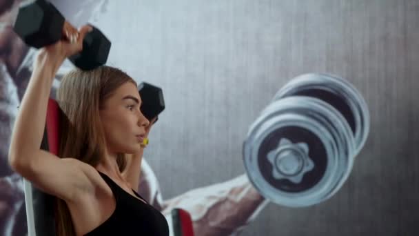 Joven mujer de fitness haciendo ejercicio en el gimnasio con pesas — Vídeo de stock