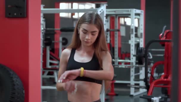 Gelbe Smart Watch zeigt Herzfrequenz trainierender junger Frau im Fitnessstudio — Stockvideo