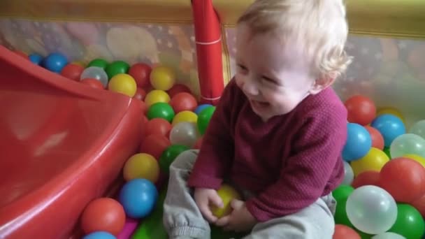 Roztomilá chlapeček hraje fotbal a směje se v hrací místnosti — Stock video