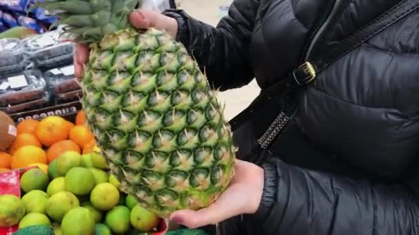Крупный план съемки женской руки при выборе свежего ананаса — стоковое видео