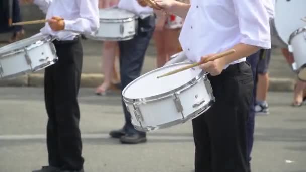 Şehir caddesinde kostümlü davulcu kız ve erkek şenlikli yürüyüş Sokak performansı. Erkek el davulcularının yakın çekim ilerler ve sopalarının davuluna vuruyorlar. — Stok video