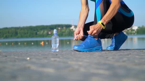 Primer plano de los pies de la corredora femenina preparándose atando zapatillas de correr. Movimiento lento — Vídeos de Stock